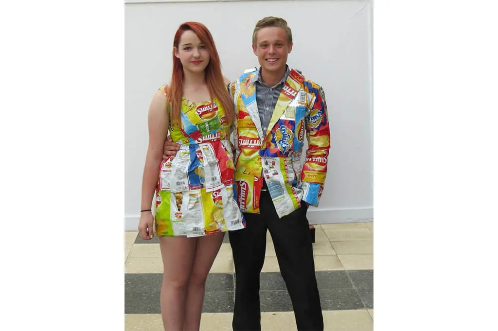 Couple costume crafted from snack wrappers—colorful DIY recycled Halloween outfits
